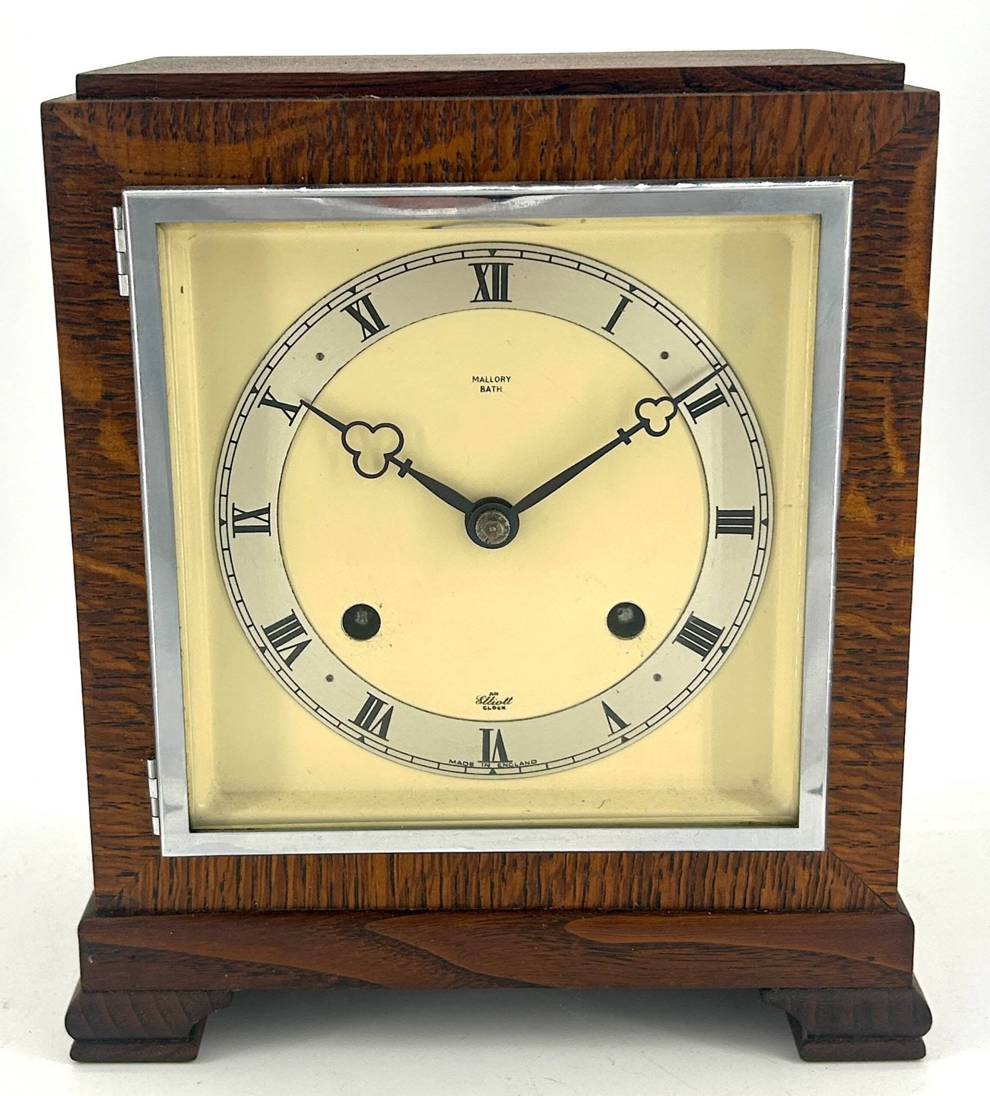 Stylish oak case mantle clock with a square chrome bezel and original Elliot dial . 8 day gong striking movement.