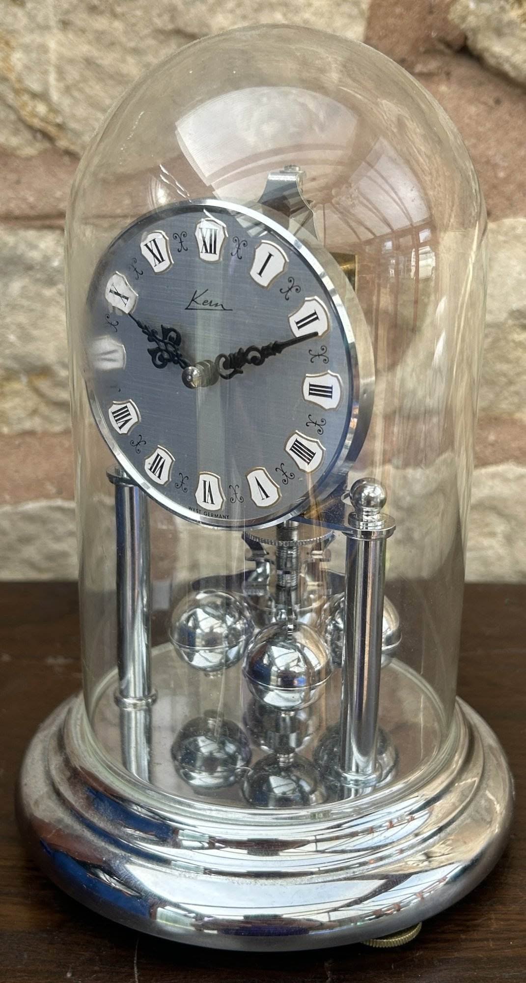 Fantastic Kern Torsion clock ca 1960 Original dial with original black ornate hands under glass dome. The base, pillars and pendulum are all finished in chrome.